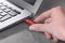 Woman attaching usb flash drive into laptop at light grey table, closeup
