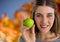 Woman in Autumn with apple in front of orange leaves