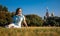 Woman in autumnal park. lonely middle-aged woman sitting on grass and looking away happy. Middle aged caucasian woman sits alone