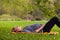 Woman awaiting for a baby, cute pregnant female lying down on fresh green grass in the garden, sunny day, happy and healthy pregna