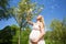 Woman with baby bump standing next to sakura tree