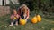 Woman and baby carves pumpkin Jack lantern for Halloween party. Slow motion. Outdoors