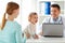 Woman with baby and doctor with laptop at clinic