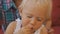 Woman with baby trying japanese cuisine. Close-up of blonde blue-eyed baby girl taking by hand and biting cabbage on