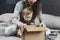 Woman and baby unpacking cardboard box with surprise. International shopping with shipment worldwide