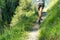 Woman back hiking in a forest path