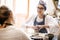 Woman on the background of a shelf in a ceramic workshop makes dishes