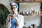 Woman on the background of a shelf in a ceramic workshop makes dishes