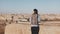 Woman with backpack comes up to Jerusalem panorama. Excited Caucasian tourist looks at ancient old town in Israel. 4K.