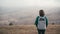 A woman with a backpack enjoying the top view of the valley covered with fog