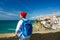 Woman with a backpack enjoys a view of the ocean coast near Azenhas do Mar, Portugal