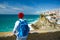 Woman with a backpack enjoys a view of the ocean coast near Azenhas do Mar, Portugal