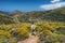 Woman with a backpack hiking on a hiking trail on Andros island, Greece