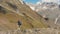 Woman with backpack hiking on mountain ridge in Caucasus mountains, Georgia