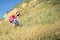 A woman with a backpack looks up the hill and look back