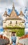 Woman with backpack posing on bridge in front of Vajdahunyad castle in Budapest, Hungary