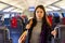 Woman with backpack on shoulder standing in aisle between seats in train