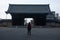 A woman with a backpack is standing in front of a gate in Toji Temple area in Kyoto in Japan in early spring