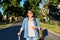 Woman with backpack suitcase looking at camera standing on street road