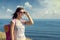 A woman with a backpack travels along seashore