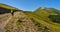 Woman with backpack walking along a path in the Caucasus mountains