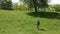 Woman with backpack walking down a hill in the sunny day