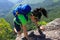 Woman backpacker climbing up on mountain rock