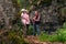 Woman backpacker communicates with two teenage girls among the rocks in a natural landscape