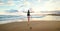 Woman backpacker greeting a sunset at the ocean coast