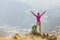 Woman backpacker and hiker looking at the view with arms outstretched on mountain top