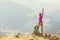 Woman backpacker and hiker looking at the view with arms outstretched on mountain top