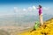 Woman backpacker and hiker looking at the view with arms outstretched on mountain top