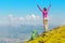 Woman backpacker and hiker looking at the view with arms outstretched on mountain top