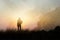 Woman backpacker hiking on mountain peak cliff in the mist