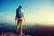 woman backpacker looking down on mountain top rock