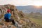 Woman backpacker looks at the landscape through binoculars