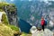 Woman backpacker looks at Lysefjord, Norway