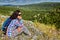 Woman backpacker rests on top of the mountain