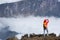 Woman backpacker taking selfie on mountain peak cliff edge