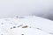 Woman backpacker tourist hiking ascending snow mountain covered