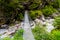 Woman backpacker on trekking path crossing a suspended bridge in Annapurna Conservation Area, Nepal