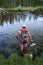 Woman backpacker wading across river