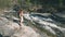 Woman backpacker walking on rock exploring waterfall in alpine valley, freedom backpacking travel concept