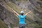 Woman with backs open arms in a mountainous landscape