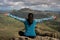 Woman backwards sitting at the of a mountain looking at the landscape