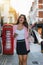 Woman with bags in her hand is shopping on a busy shopping highstreet in London