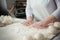 Woman baker make buns from dough