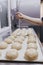 Woman in bakery preparing sweets adding sugar