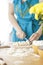 Woman baking pies. woman divides the dough, on the table is a skipping rope and flour