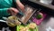 Woman baking sunflower oil. Cheese, sliced onions, mashed potatoes and fried mushrooms are on the plate.